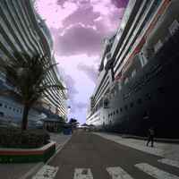 A photo of a man walking between two cruise ships